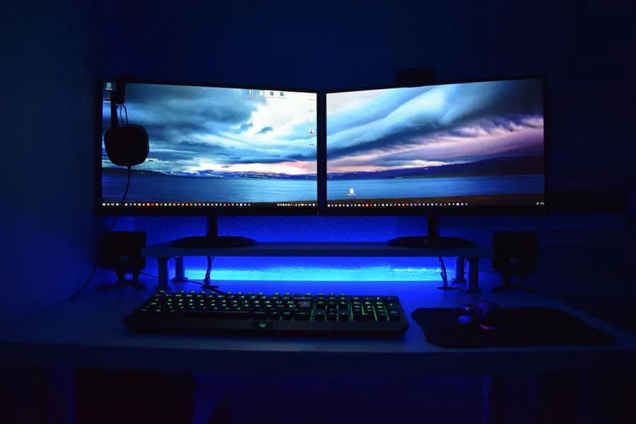 Mavi ışıklı çift monitörlü oyun masası